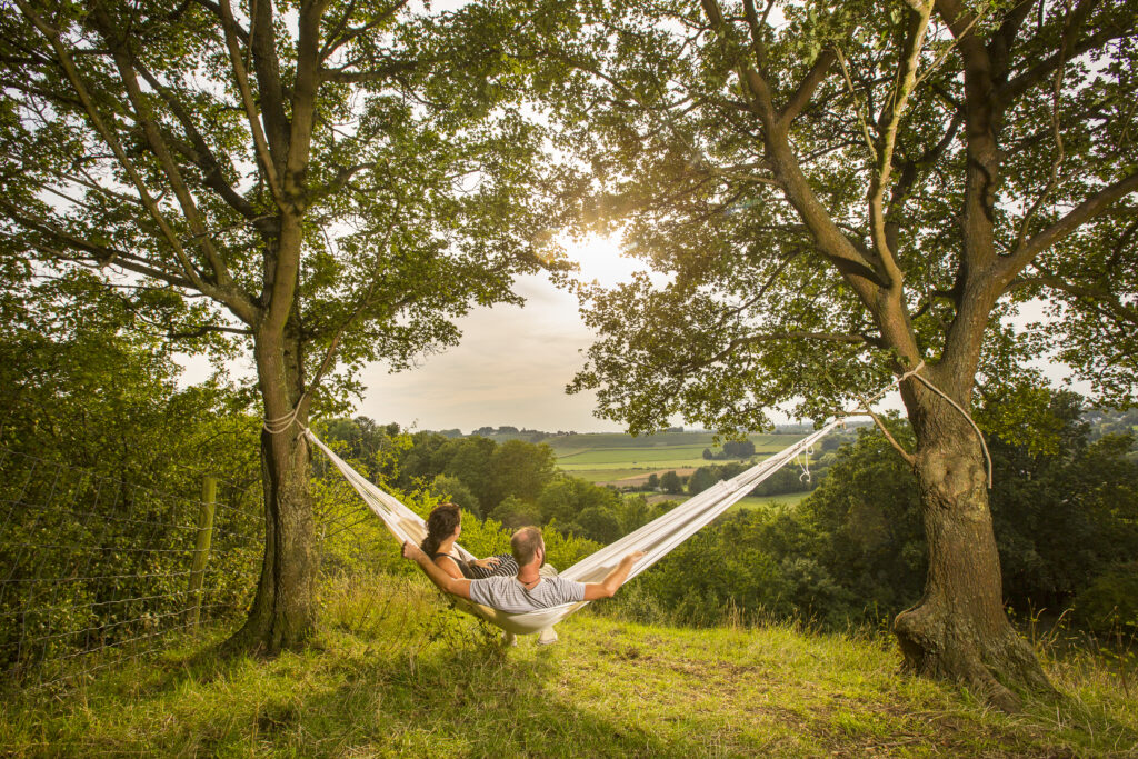 Koppel hangt romantisch in hangmat met uitzicht op het Heuvelland